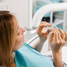 Patient holding clear aligner in treatment room