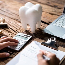 Patient calculating cost on desk with laptop