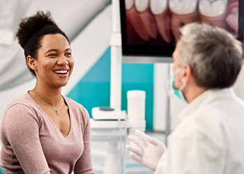 Woman in dental chair smiling at her dentist in Londonderry