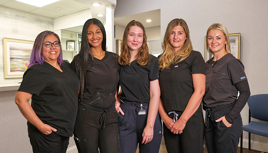 Five smiling clinical team members at Miles of Smiles