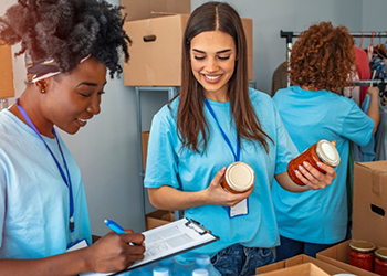 Three adults working at a canned food drive