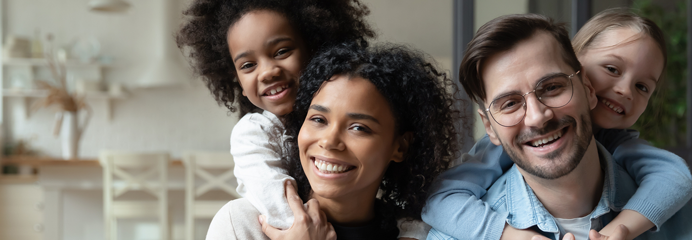 Family of four smiling together after cosmetic dentistry in Londonderry