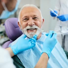 Senior dental patient smiling during his checkup