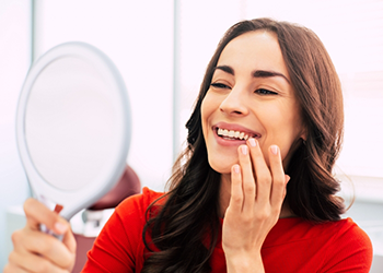 Dental patient admiring her smile in a mirror