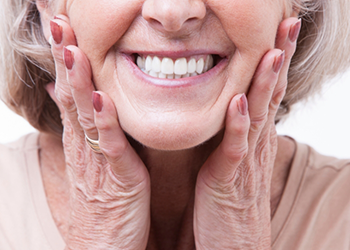 Close up of smiling senior woman touching her face