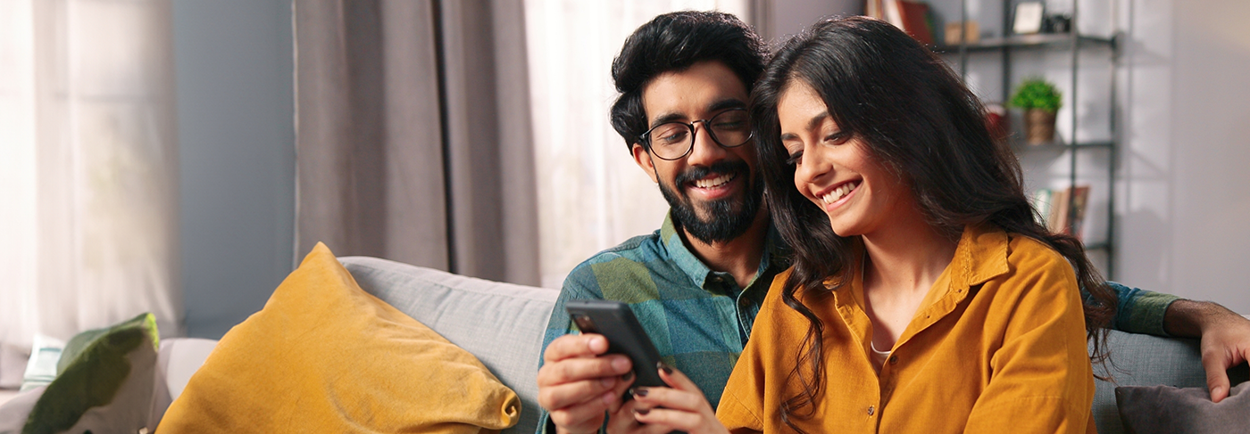 Man and woman looking at a smartphone together and smiling