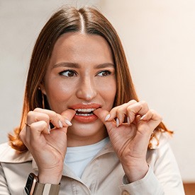 Patient putting on clear aligner in treatment room