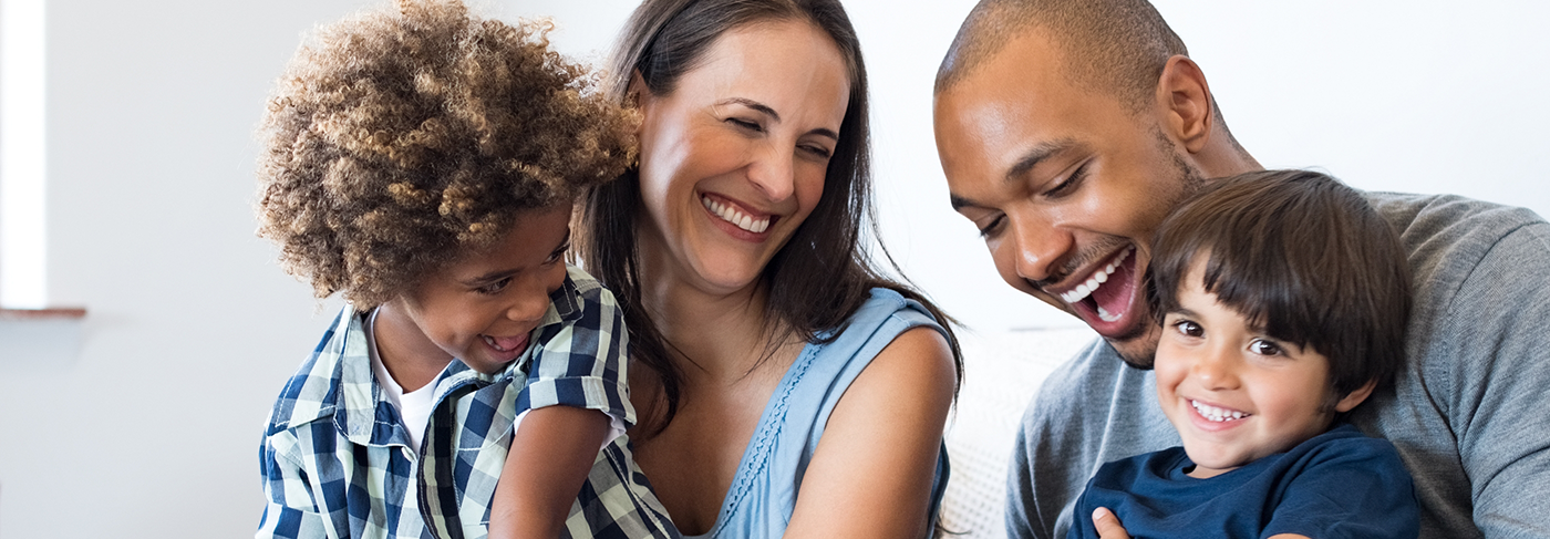 Family of four laughing together after restorative dentistry in Londonderry