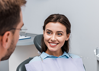 Woman in dental chair listening to her dentist